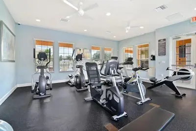 a gym with several treadmills and exercise bikes at New townhouse in Clermont -Orlando area in Orlando