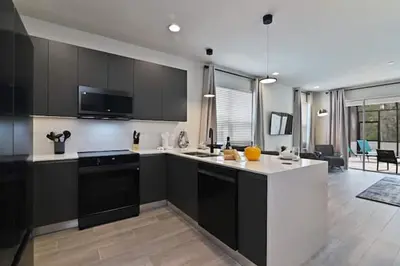 a kitchen with black and white cabinets and a living room at New townhouse in Clermont -Orlando area in Orlando