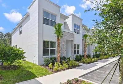 a white house with palm trees in front of it at New townhouse in Clermont -Orlando area in Orlando