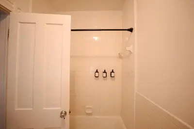a bathroom with a shower with a tub and a toilet at Norment Parry by The Wellborn in Orlando