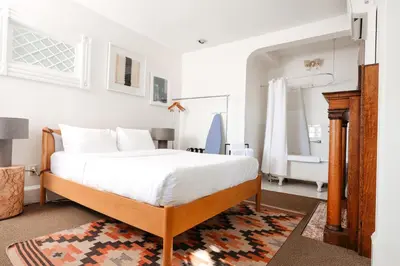 a bedroom with a large bed and a bathroom at Norment Parry by The Wellborn in Orlando