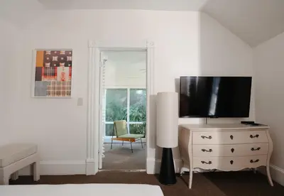 a living room with a tv and a dresser with a television on it at Norment Parry by The Wellborn in Orlando