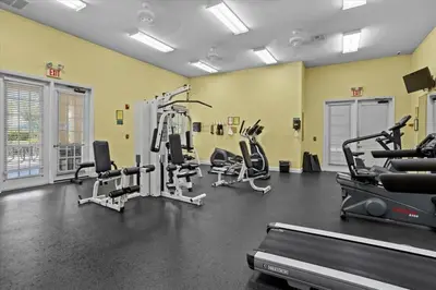 a gym with treadmills and machines in a room at True Fantasies 101 in Kissimmee