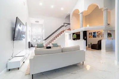 a living room with a couch and a staircase at Spacious Orlando Getaway Vacation Home in Orlando