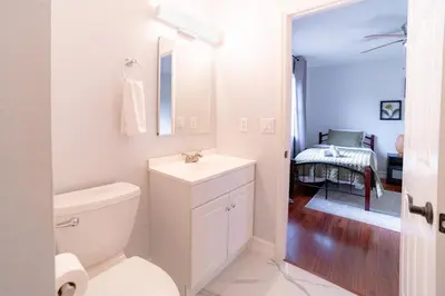 a white bathroom with a toilet and a sink at Spacious Orlando Getaway Vacation Home in Orlando