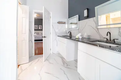 a white kitchen with a sink and a mirror at Spacious Orlando Getaway Vacation Home in Orlando