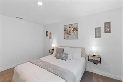 a white bedroom with a bed and two lamps at Elegant Home near Disney - pool - free parking in Kissimmee