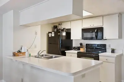 a kitchen with a sink and a black refrigerator at Near Disney! Pool and Hot Tub with Free Parking in Kissimmee