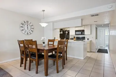a kitchen and dining room with a wooden table and chairs at Near Disney! Pool and Hot Tub with Free Parking in Kissimmee