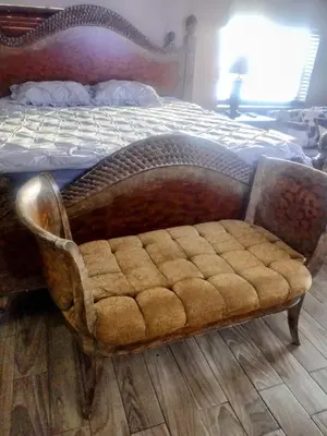 a bed with a wooden frame with a tufted foot board at A great environment living space in Orlando