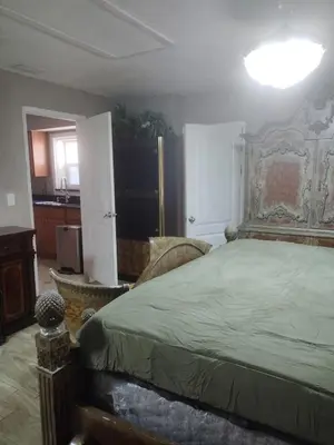 a bedroom with a large bed and a kitchen at A great environment living space in Orlando