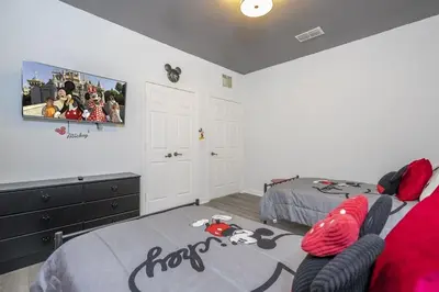 a bedroom with two beds and a tv on the wall at Apto 3Q em Kissimmee – Conforto e Localização in Kissimmee