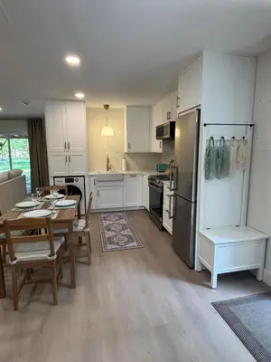 a kitchen with white cabinets and a table and a dining room at Parks2Coast Trail Casita in Sanford