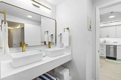 a white bathroom with two sinks and a mirror at Well-Located 1BR Kitchen Near Theme Parks in Orlando