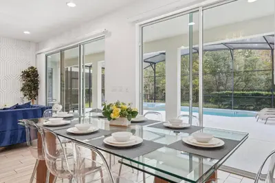 a dining room with a glass table and chairs at Large Orlando Home 8BR Great Location in Kissimmee