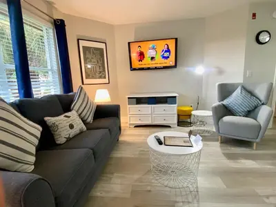 a living room with a couch and a tv at Sea World Orlando Apts Parks Convention Centre in Orlando