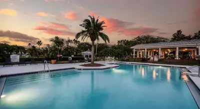 a swimming pool with a palm tree and a building at Quiet Gated Condo Near Universal with Pool and View in Orlando