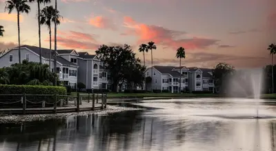 a pond in front of houses with a fountain at Quiet Gated Condo Near Universal with Pool and View in Orlando