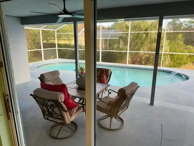 a patio with a table and chairs and a pool at Magic getaway in Kissimmee