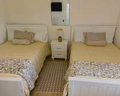 a bedroom with two beds and a nightstand and a mirror at Magic Palms House 10 Min to Parks in Kissimmee