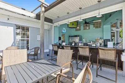 a patio with a table and chairs and a bar at Magic Palms House 10 Min to Parks in Kissimmee