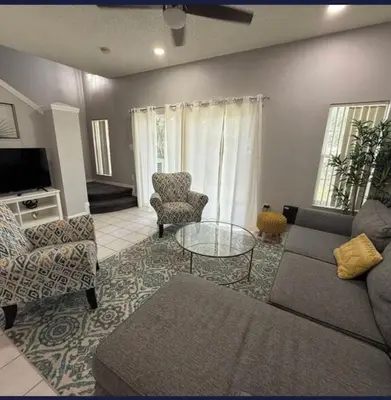 a living room with a couch and a table and chairs at TownHouse at Emerald Island Resort Near Disney in Kissimmee