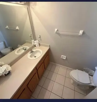 a bathroom with a sink and a toilet and a mirror at TownHouse at Emerald Island Resort Near Disney in Kissimmee