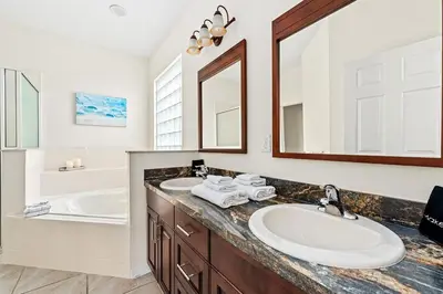 a bathroom with two sinks and a large mirror at Family Retreat at Lake Berkley Resort! in Kissimmee