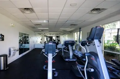 a gym with treadmills and elliptical machines at Condomínio Encantada c/ Piscina & Vista ao Lago in Kissimmee