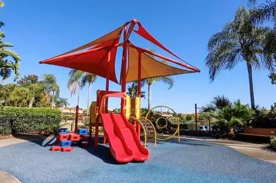 a playground with a slide and an umbrella at Condomínio Encantada c/ Piscina & Vista ao Lago in Kissimmee