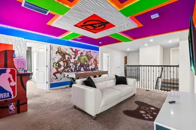 a living room with a white couch and a pool table at Close to Disney! Pool, Spa, Game, & Movie Room! in Kissimmee
