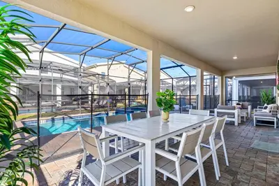 an indoor patio with a table and chairs and a pool at Close to Disney! Pool, Spa, Game, & Movie Room! in Kissimmee