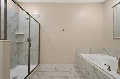 a white bathroom with a tub and a shower at Close to Disney! Pool, Spa, Game, & Movie Room! in Kissimmee
