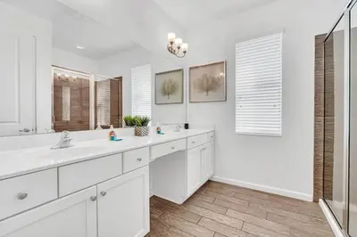 a white bathroom with two sinks and a mirror at Lakefront | Sleeps 18 | 8-Bed Villa w/ Pool & Epic in Kissimmee