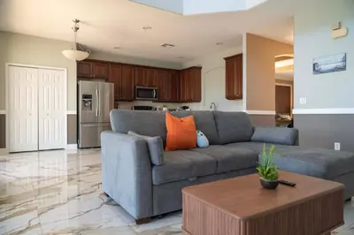 a living room with a gray couch and a table at 5BR 4BA Pool Pool Table Near Disney in Kissimmee