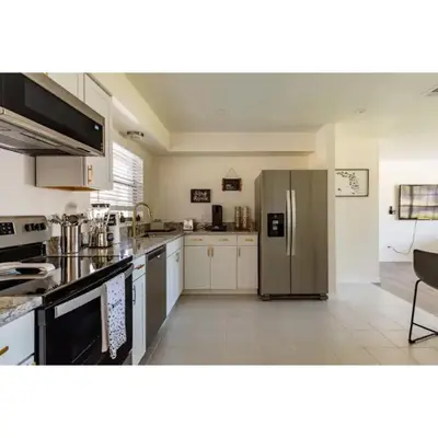 a large kitchen with a stainless steel refrigerator at Dream Getaway Nr Disney! Own Pool & Modern Feel! in Orlando