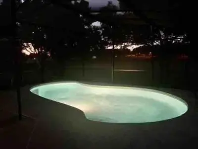 a large bath tub sitting in a yard at night at Dream Getaway Nr Disney! Own Pool & Modern Feel! in Orlando