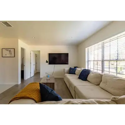 a living room with a couch and a flat screen tv at Dream Getaway Nr Disney! Own Pool & Modern Feel! in Orlando