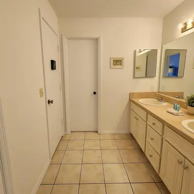 a bathroom with two sinks and a mirror at Casa 3Q c/ Piscina — 10 min da Disney in Kissimmee