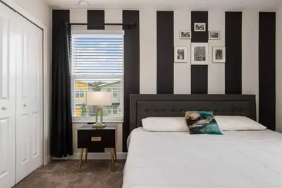 a bedroom with a black and white striped wall at Close to Disney! Pool/Spa/Game & Movie room! in Kissimmee