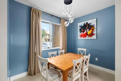 a dining room with blue walls and a wooden table and chairs at Villa near Orlando's Attractions in Orlando
