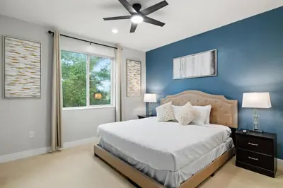 a blue bedroom with a bed and a ceiling fan at Villa near Orlando's Attractions in Orlando
