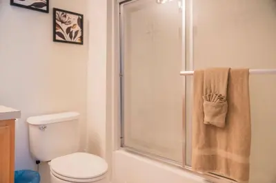 a bathroom with a shower with a toilet and a towel at Gated Pool Home 20 Min to Disney, Uni, MCO in Kissimmee
