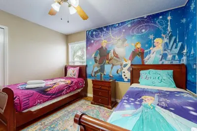 a bedroom with two beds and a disney mural at 8033 Acadia Estates Court in Orlando