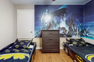 a bedroom with two beds and a superhero mural at 8033 Acadia Estates Court in Orlando