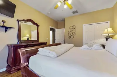 a bedroom with a large bed and a mirror at 8033 Acadia Estates Court in Orlando