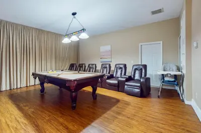 a room with a pool table and leather chairs at 8033 Acadia Estates Court in Orlando