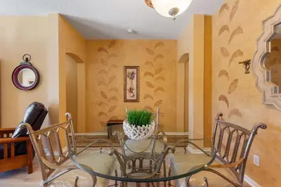 a dining room with a glass table and chairs at 2232 Wyndham Palms Way in Kissimmee