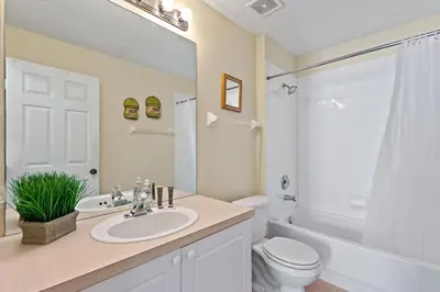 a bathroom with a sink and a toilet and a tub at 2232 Wyndham Palms Way in Kissimmee