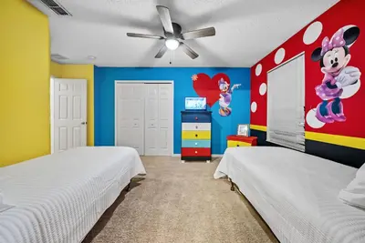two beds in a room with a mickey mouse bedroom at Cozy Villa 08 BedroomsPoolGame Room in Kissimmee